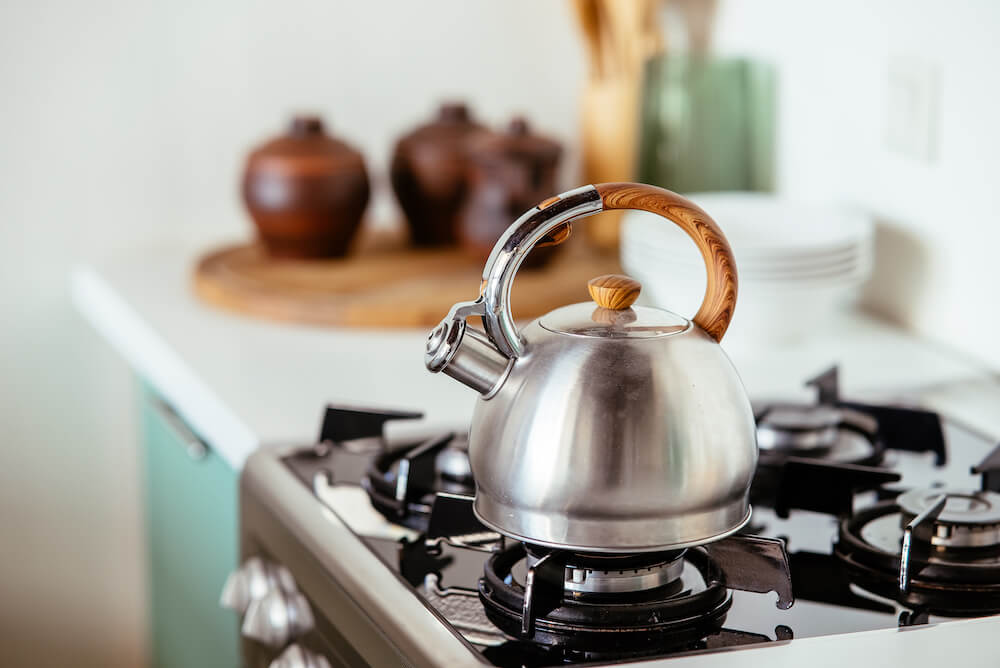 A tea kettle on a gas stove in a modern kitchen